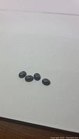 Four natural blue Pietersite oval cabochons displayed on a white background, showing polished smooth stones with distinctive blue patterns.