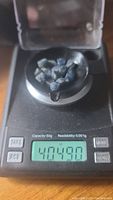 Blue sapphire crystals on a digital scale showing weight as 40.49 carats.