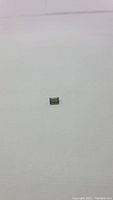 Single natural bright green baguette cut tourmaline gemstone on white background showing rectangular shape and clarity.