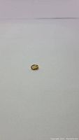 Single natural golden citrine oval cut gemstone shown from above on white background