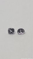 Close-up image of two views of the cushion cut off white spinel gemstone, front and side angles.