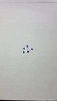 Photo showing five small oval faceted kyanite gemstones arranged loosely on plain white background. Stones have blue tones ranging from lighter cornflower blue to deeper royal blue.