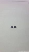 Pair of deep purple cushion cabochon cut opal gemstones displayed side by side on a plain background, showcasing their size and shape.