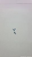 Five small oval cut teal blue kyanite gemstones on white background.
