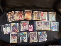 Top view showing 18 hockey cards from the 1970s, each sleeved separately, arranged on black background.