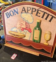 Front view of the 3D 'Bon Appétit' sign showing chef, bottle, and goblet elements.