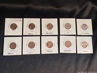 Lot of 10 Canadian pennies individually mounted and labeled with grading descriptions.