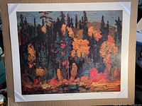 Full view of signed Group of Seven print "Algoma Bush" by J.E.H. MacDonald with protective corners and textured autumn forest scene.
