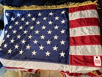 Photo showing full view of the nylon U.S. flag with stars and stripes and yellow fringe detail.