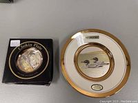 Two Chokin Art Collection plates, one in box and one out showing gold rim and artwork of two loons