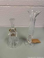 Wide view of crystal bell and clear crystal vase with swirling pattern showcasing both items in the lot.