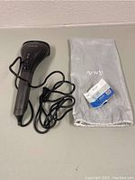 Full view of the SALAV handheld garment steamer with attached power cord and the gray fabric carrying pouch with SALAV logo alongside a product tag.