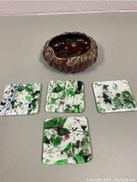 Pottery box and four glass coasters arranged on light surface, showing the box above the coasters