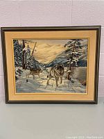 Full front view of framed painting showing wolves in snowy forest with mountains and lake background.