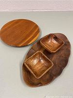 Overview of all four wooden items: round plate, large oval tray, and two small square bowls.