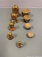 Five wooden nesting dolls arranged in order of size, with the two smallest dolls open to show hollow interiors.