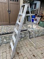 Full side view of aluminum step ladder showing overall structure and condition.