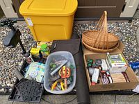 Wide shot of the lot showing yellow storage tote, brown fork basket, black trays, clear bin with tools and various garden items