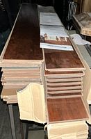 Two boxes of Armstrong hardwood flooring planks stacked horizontally with packaging partially open showing plank ends and documentation on top.