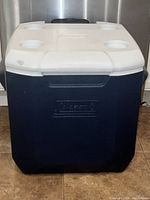 Front view of blue Igloo cooler with white lid and logo embossed on the front.