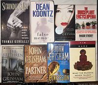 Photo shows eight used books including Schindler's List, three John Grisham novels, and other titles.