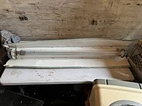 Photo of large grow light fixture with tubular fluorescent bulb inside a white reflector housing, showing some wear and use marks.