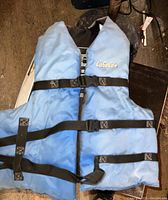 Photo of a blue adult large life jacket by Cabela's with three black adjustable straps and buckles, showing overall condition and branding.