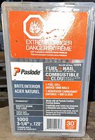 Sealed box of Paslode Fuel & Nail Combo Kit labeled as extremely flammable, containing 1 fuel cell and 1,000 nails for framing nailers