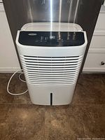 Front view of white Whirlpool dehumidifier showing vented front panel and black digital control panel on top.