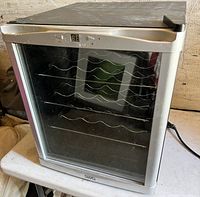 Front view of the SWG wine fridge showing the glass door with internal metal wire racks and digital display.