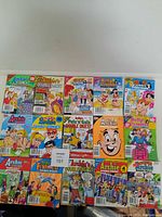 Top view of 15 Archie comic books arranged side by side showing front covers, featuring Betty and Veronica, Archie Double Digest, Archie Jumbo Comics, and other titles with colorful illustrations.