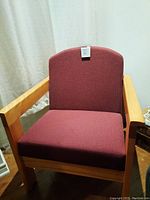 Front view of a burgundy upholstered arm chair with solid wood frame and arms, showing the fabric and overall construction.