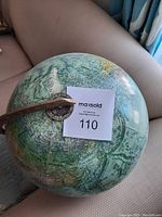 Photo of the globe's top showing country names in French and part of the wooden meridian ring.
