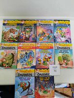 Front view of 8 Geronimo Stilton children's books from Heromice and Cavemice series laid out on a white surface showing full colorful illustrated covers.