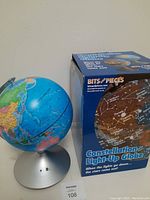 Photo of the globe mounted on silver base with visible geographic world map and a label with number 108.