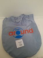 Photo of the soft light grey carrying bag with Web Around logo in blue and orange. Shows the bag size and logo clearly.