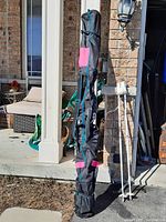 Full view of the ski bag standing upright on a driveway near a porch.