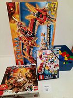 Three boxed LEGO sets displayed: LEGO Chima Fire Phoenix 70146, LEGO Pyramid 21024, LEGO Movie 70803.