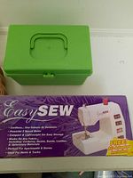 Top view of closed green plastic sewing kit box showing handle and latch.