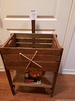 Front view of vintage wooden rack showing crossed golf club sticks decoration and lower magazine holder with a magazine in it.