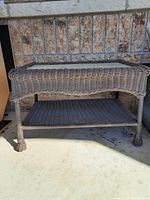 Front angle showing wicker weave, lower shelf and table legs.