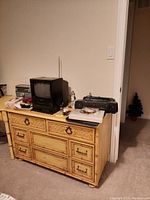 Full view of yellow bamboo 4 drawer dresser with items on top for size reference