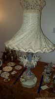 Full view of the porcelain lamp with fabric lampshade demonstrating overall size and decorative elements.