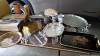Photo showing various serving and party items arranged on a table including trays, mugs, bowls, and bar accessories as listed by seller.