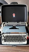 Front view of Smith Corona electric typewriter in open black case showing keyboard and type area.