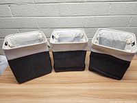 Three Keegh fabric storage organizers arranged side-by-side showing front view with white top folded over black bottom.