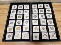 Two display panels with a total of 48 foreign coins individually mounted in cardboard holders.