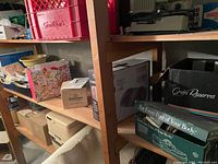 Shelf with various storage boxes, crates, and containers including floral print box and cardboard boxes