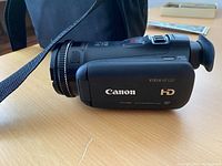 Side view of camcorder showing Canon branding and VIXIA HF G20 HD markings