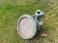 Full view of the birdbath showing the tree trunk styled base and round basin with leaf pattern rim.